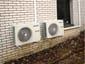Två Panasonic värmepump-utedelar monterade på fasad